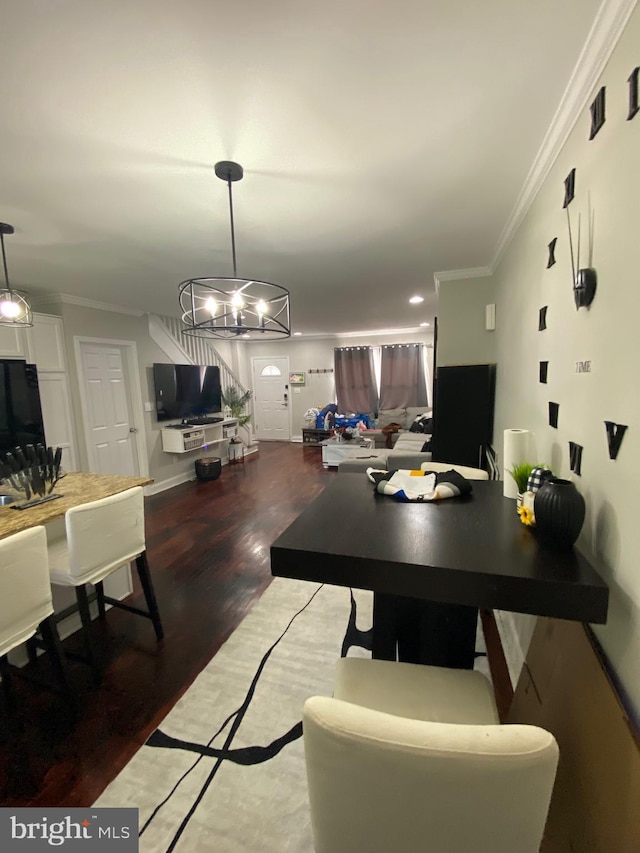 dining area featuring hardwood / wood-style flooring, ornamental molding, and a chandelier