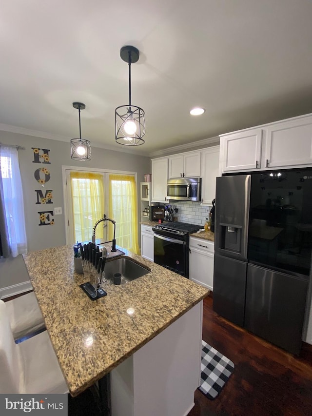 kitchen featuring sink, white cabinets, black appliances, and a center island with sink