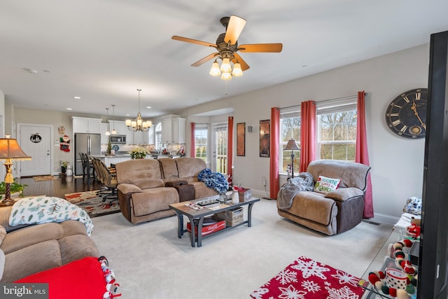 living room featuring ceiling fan with notable chandelier