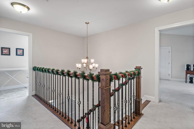 hallway featuring light colored carpet and a notable chandelier