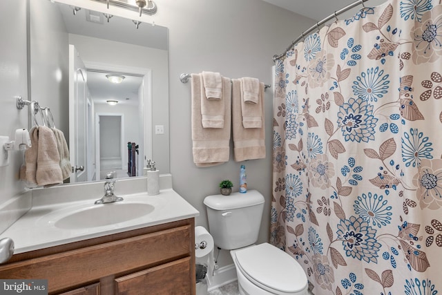 bathroom featuring vanity, curtained shower, and toilet