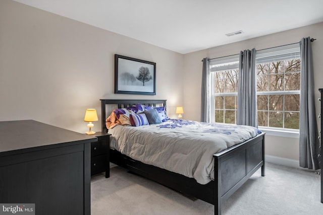 bedroom featuring light carpet and multiple windows