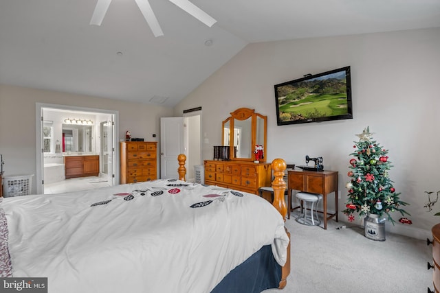 bedroom with ceiling fan, light colored carpet, ensuite bathroom, and vaulted ceiling