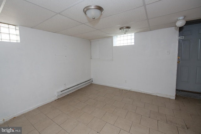 basement featuring a drop ceiling and a baseboard radiator