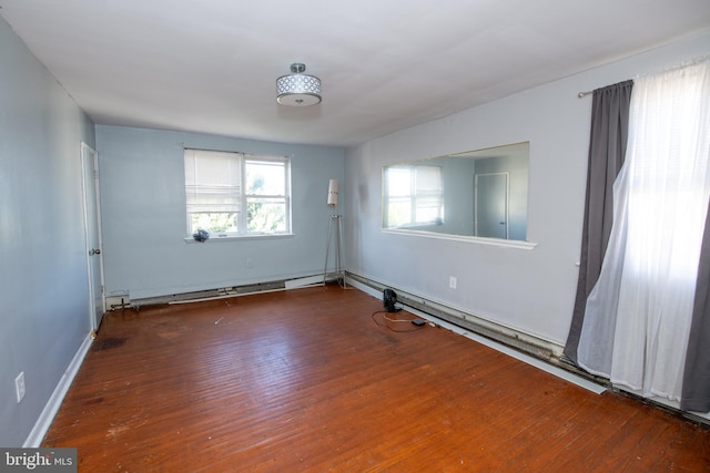 unfurnished room with hardwood / wood-style floors and baseboard heating