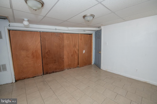 interior space featuring a drop ceiling and a closet