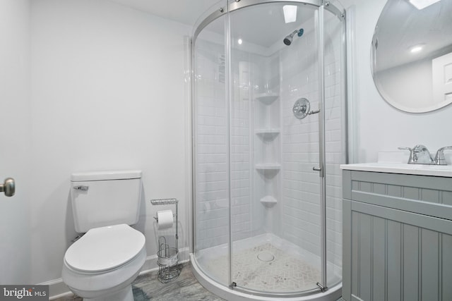 bathroom featuring vanity, toilet, and a shower with shower door