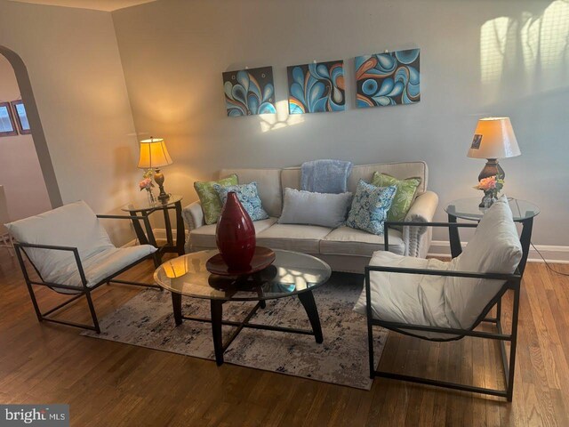 4807 Cordelia Ave, Baltimore, MD 21215 - living area featuring arched walkways, wood finished floors, and baseboards