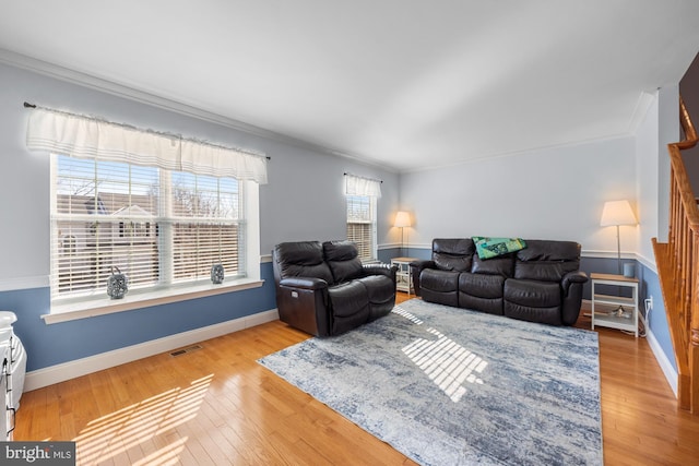 living room with crown molding and light wood-type flooring