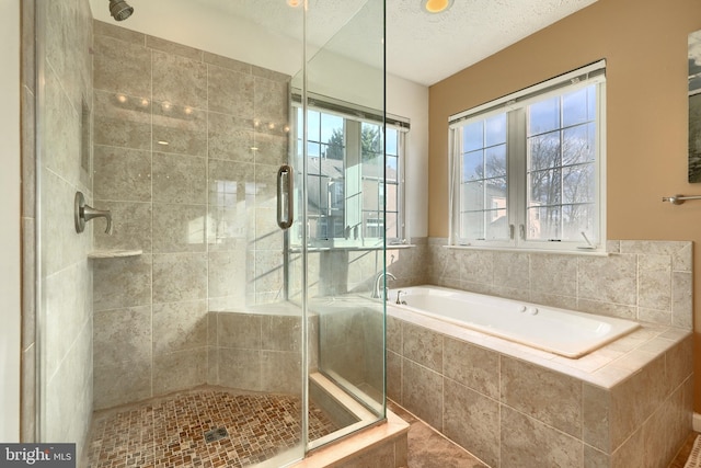 bathroom featuring a textured ceiling and shower with separate bathtub