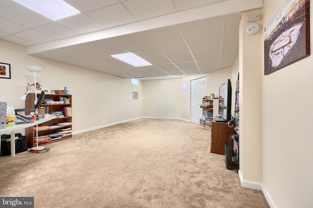 basement featuring a paneled ceiling and carpet