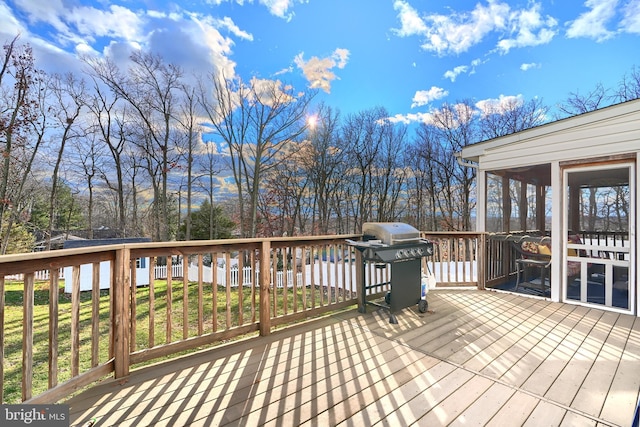 deck with a sunroom, a grill, and a yard