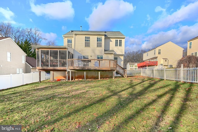 back of property with a lawn, a wooden deck, and a sunroom