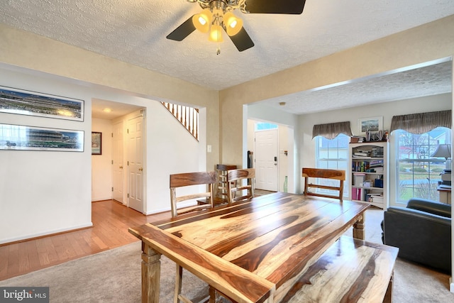 dining room featuring ceiling fan, a textured ceiling, and light hardwood / wood-style flooring