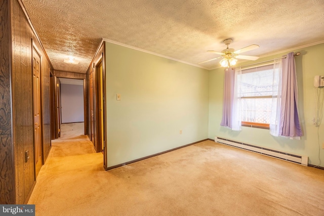 carpeted empty room with ceiling fan, ornamental molding, a textured ceiling, and a baseboard heating unit