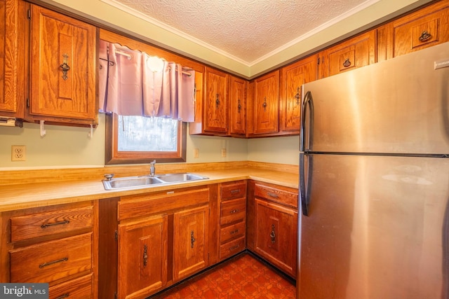 kitchen with stainless steel fridge, a textured ceiling, and sink