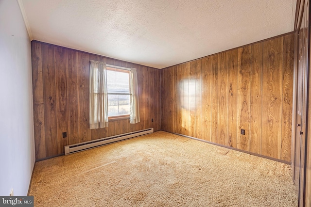 empty room featuring wood walls, carpet floors, a baseboard radiator, and a textured ceiling