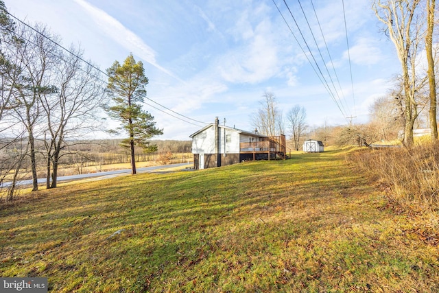 view of yard with a shed, a rural view, and a deck