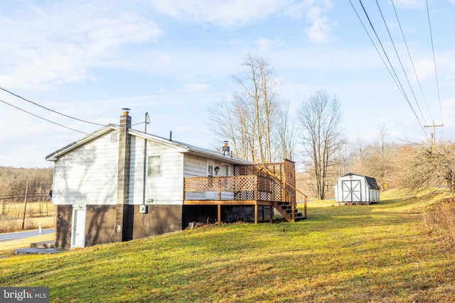 back of house with a lawn, a storage unit, and a wooden deck