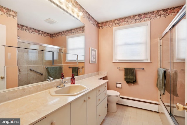 bathroom featuring baseboard heating, toilet, vanity, and walk in shower