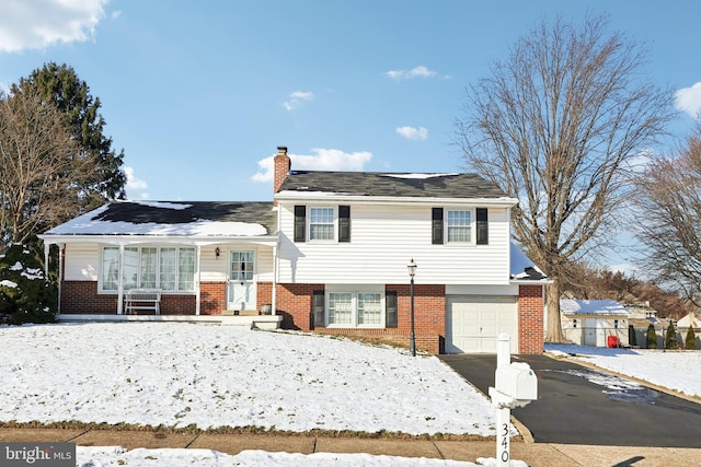 split level home featuring covered porch and a garage