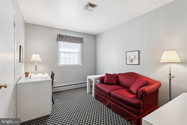 bedroom with carpet floors and a baseboard heating unit