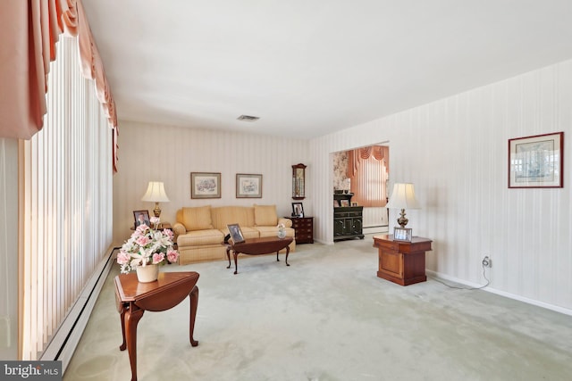 carpeted living room with a baseboard heating unit