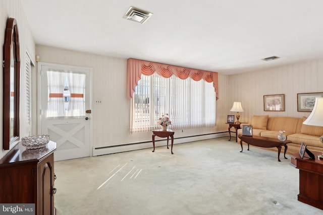 sitting room featuring baseboard heating, light carpet, and a healthy amount of sunlight