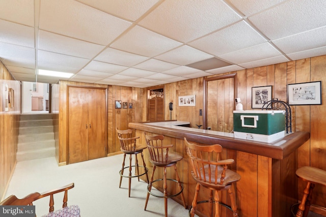 bar with wooden walls and a drop ceiling