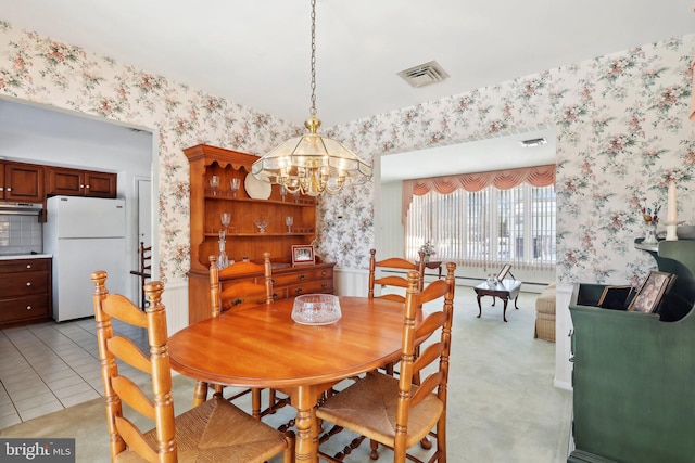 dining area featuring light tile patterned floors and an inviting chandelier