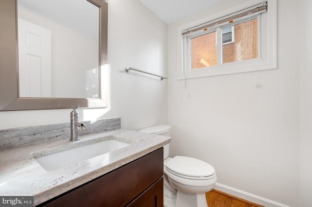 bathroom featuring vanity, hardwood / wood-style floors, and toilet