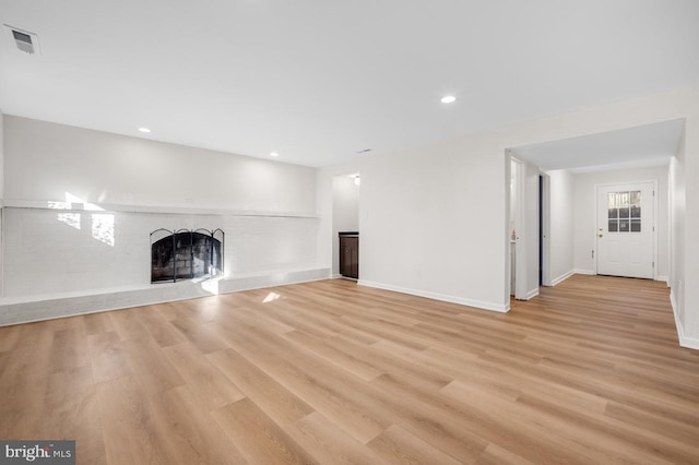 unfurnished living room with light hardwood / wood-style flooring and a fireplace