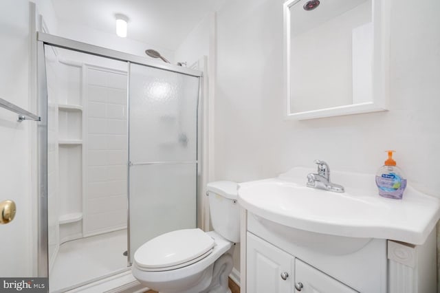 bathroom with walk in shower, vanity, and toilet