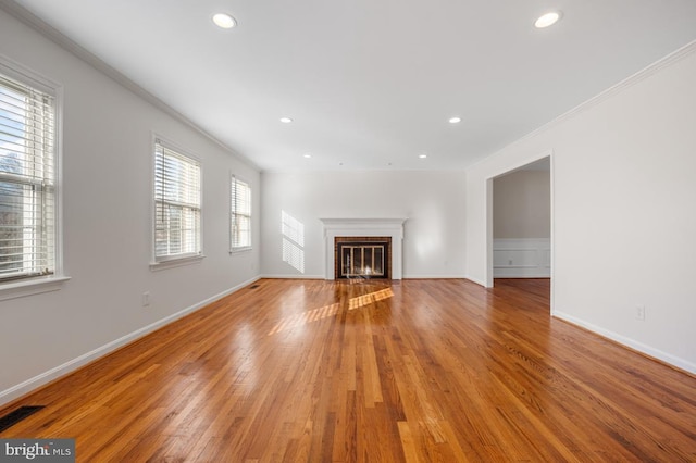 unfurnished living room with ornamental molding and light wood-type flooring