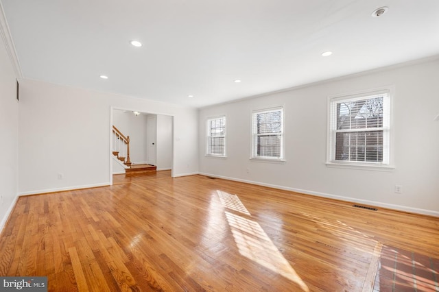 unfurnished living room with ornamental molding and light hardwood / wood-style flooring