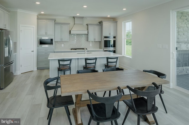 kitchen with a breakfast bar, backsplash, a center island with sink, appliances with stainless steel finishes, and custom range hood