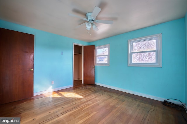 unfurnished bedroom featuring ceiling fan, wood-type flooring, and a closet