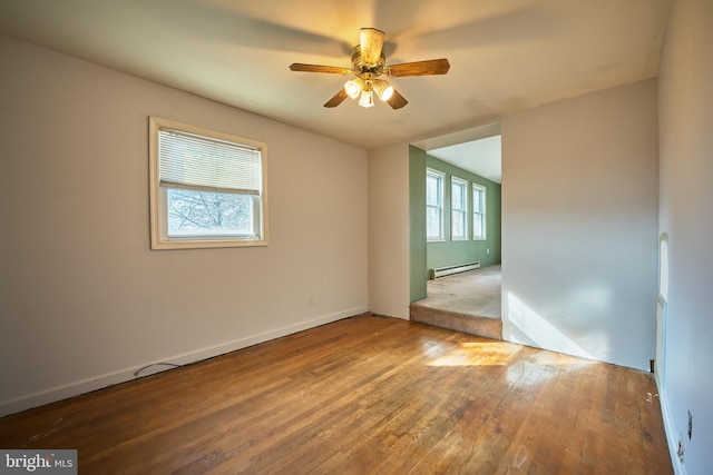 unfurnished room featuring ceiling fan, baseboard heating, and hardwood / wood-style floors