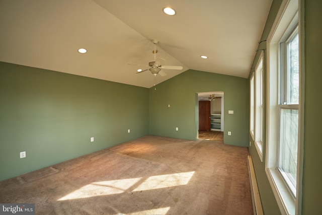 empty room with baseboard heating, carpet flooring, lofted ceiling, and ceiling fan