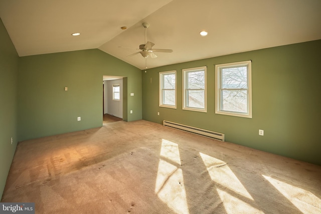 carpeted spare room with ceiling fan, a baseboard heating unit, vaulted ceiling, and a wealth of natural light