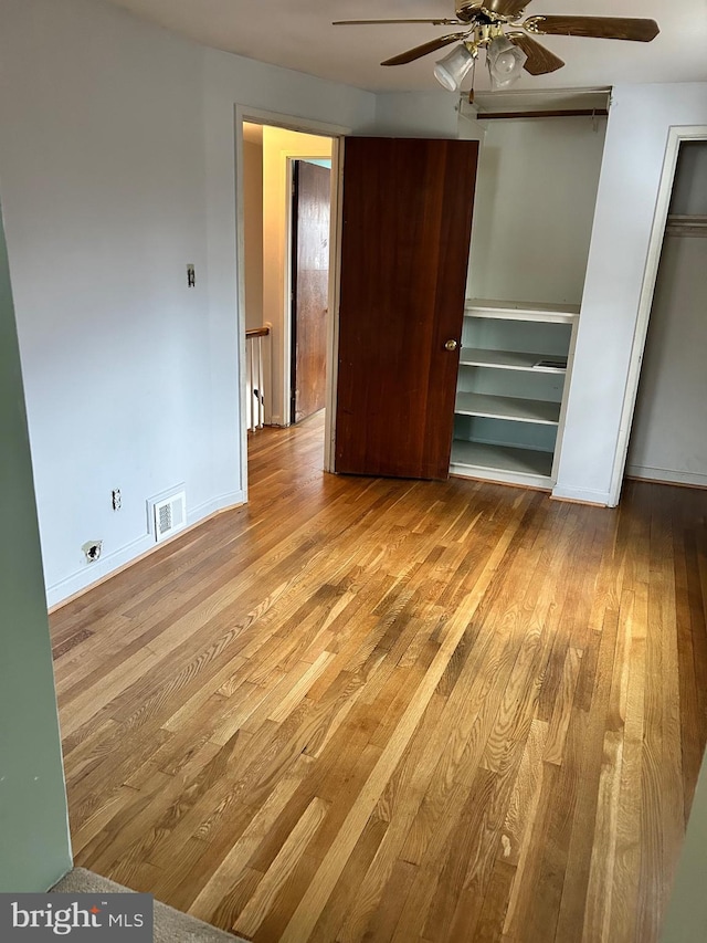 unfurnished bedroom featuring ceiling fan, light hardwood / wood-style floors, and a closet