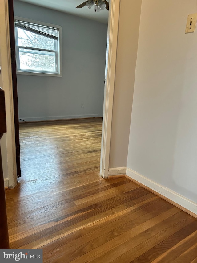 spare room with ceiling fan and wood-type flooring