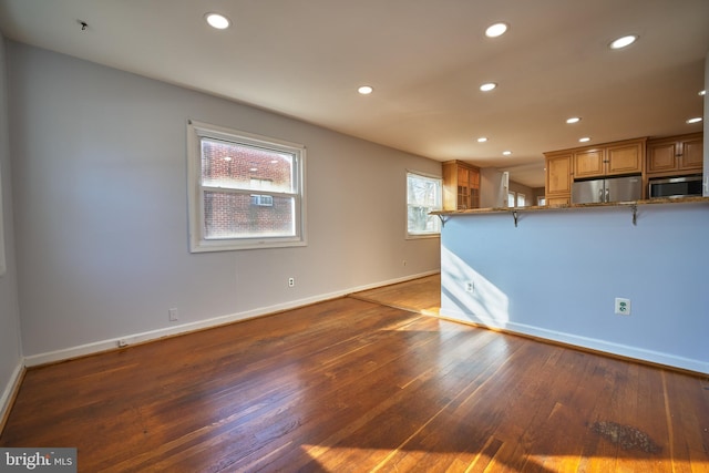 unfurnished living room with dark wood-type flooring