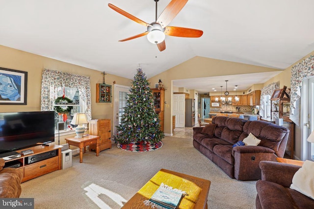 living room with ceiling fan, lofted ceiling, and light carpet