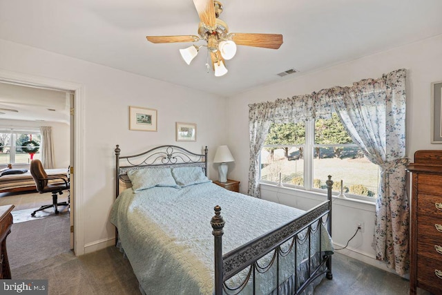 bedroom with ceiling fan, carpet floors, and multiple windows