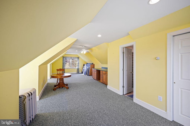 additional living space with ceiling fan, radiator heating unit, carpet, and lofted ceiling