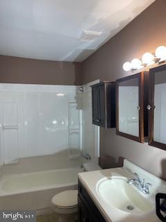 full bathroom with bathtub / shower combination, vanity, and toilet