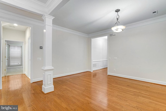 unfurnished room with visible vents, light wood-style flooring, crown molding, and ornate columns