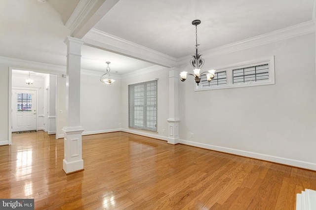 unfurnished dining area featuring baseboards, ornate columns, an inviting chandelier, light wood-style flooring, and crown molding