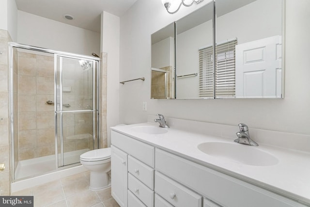 bathroom featuring a sink, toilet, a stall shower, and tile patterned floors